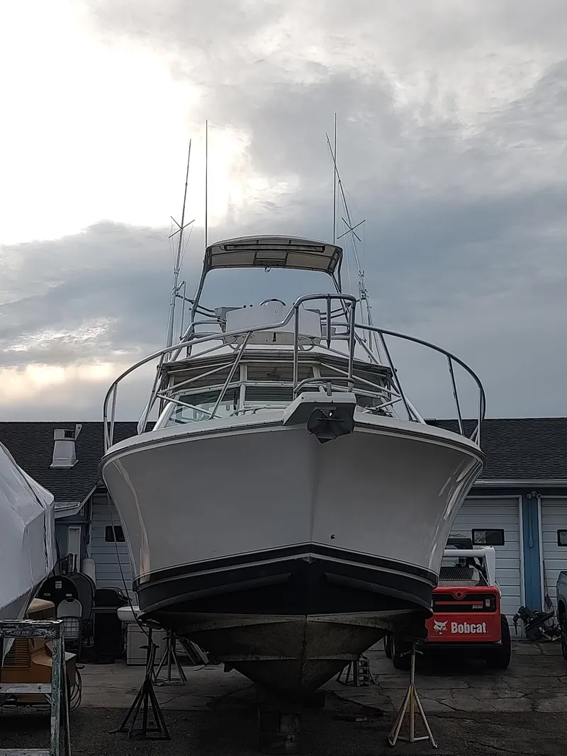Slide: The Image of 1998 Cabo 31 Express boat in a marina, overcast sky background. - 15