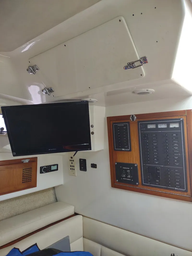 Slide: The Image of Interior of 1998 Cabo 31 Express boat with control panel and mounted TV. - 17