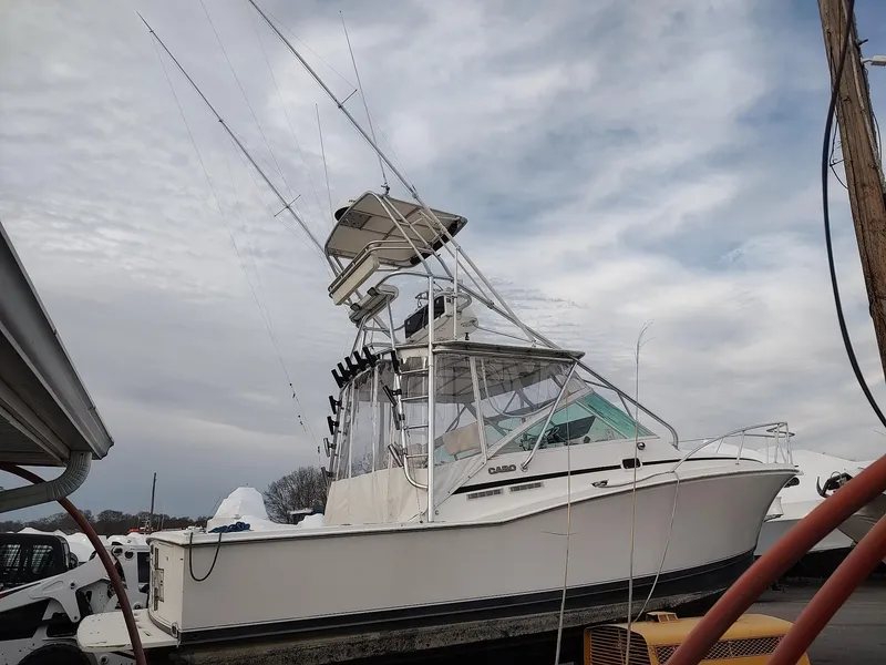 Slide: The Image of 1998 Cabo 31 Express boat with tower, docked under cloudy sky. - 2