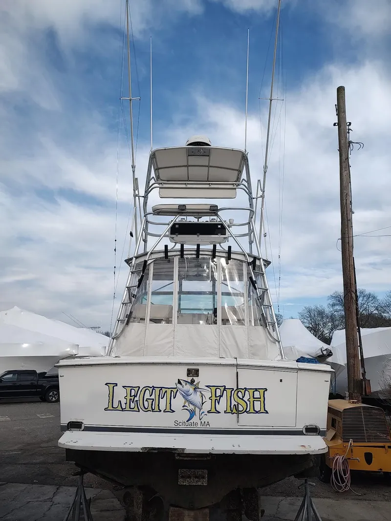 Slide: The Image of 1998 Cabo 31 Express boat with "Legit Fish" name, docked under cloudy sky. - 4