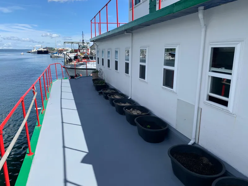 Slide: The Image of 1938 Custom Ferry deck with potted plants, red railings, and ocean view. - 10