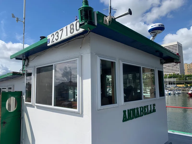 Slide: The Image of 1938 Custom Ferry Annabelle docked at marina with cityscape background. - 11