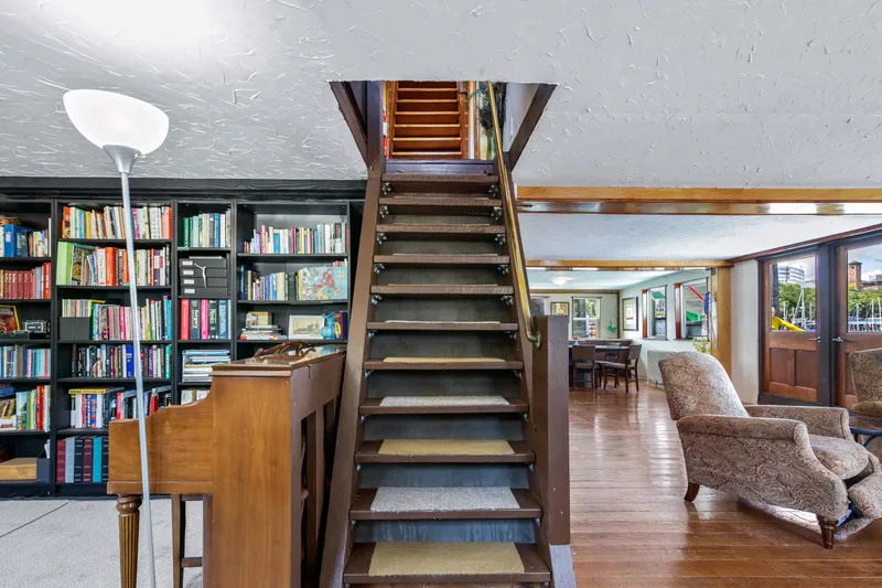 Slide: The Image of 1938 Custom Ferry interior with wooden staircase, bookshelves, and cozy seating area. - 17