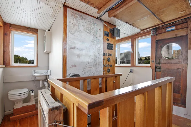 Slide: The Image of 1938 Custom Ferry interior with wooden finishes, navigation map, and small bathroom. - 18