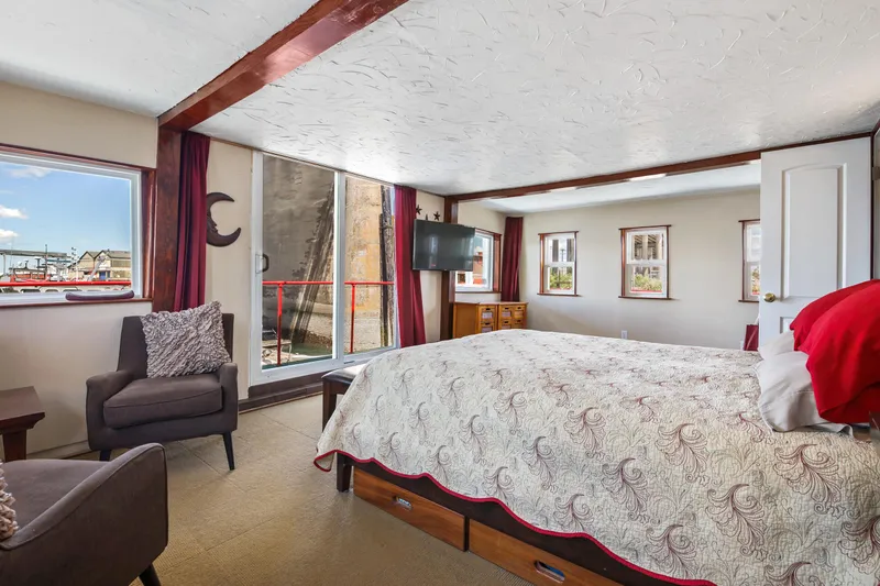 Slide: The Image of Spacious bedroom on a 1938 custom ferry with waterfront views, cozy seating, and modern amenities. - 2