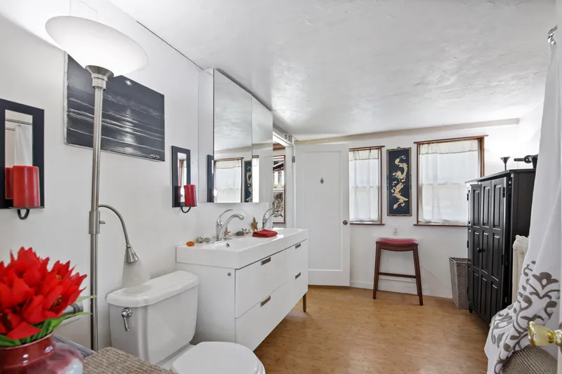 Slide: The Image of Vintage 1938 Ferry Custom bathroom with modern decor, white vanity, and red accents. - 22