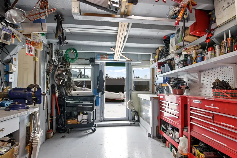 Slide: The Image of Workshop interior with tools, red tool cabinets, and a view of a 1938 Ferry Custom boat outside. - 24