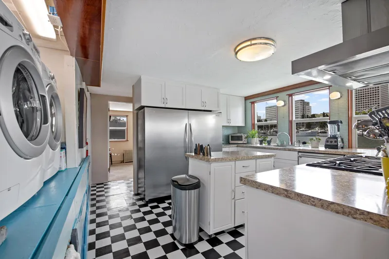 Slide: The Image of Modern kitchen with checkered floor, stainless steel appliances, and large windows in a 1938 Ferry Custom home. - 27
