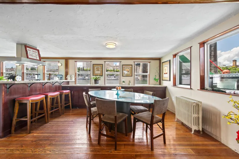 Slide: The Image of Dining area on a 1938 custom ferry with wooden floors and waterfront views. - 29
