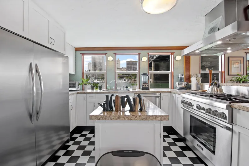 Slide: The Image of Modern kitchen with stainless steel appliances, checkered floor, and city view through large windows. - 3