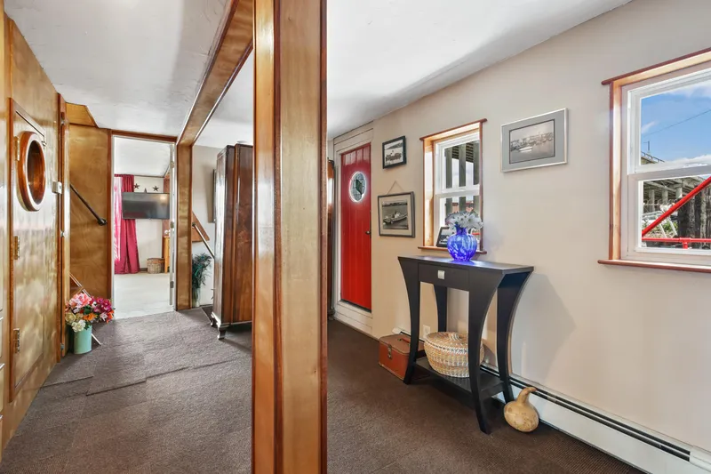Slide: The Image of Interior of a 1938 custom ferry with wooden walls, red door, and nautical decor. - 34