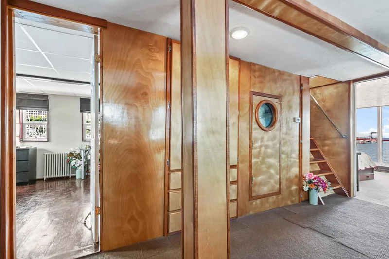 Slide: The Image of 1938 Custom Ferry interior with wooden walls, porthole door, and staircase. - 35