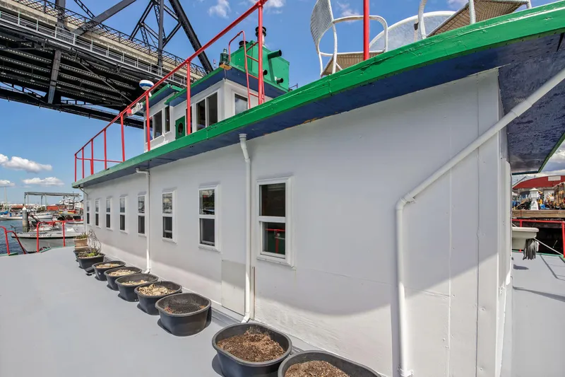 Slide: The Image of 1938 Custom Ferry with potted plants on deck under a bridge. - 45