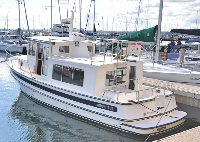 The Image of 2025 Nordic Tug 34 docked at a marina, surrounded by other boats. - 0