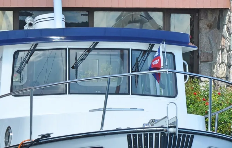 Slide: The Image of 2025 Nordic Tug 34 boat docked near a building. - 9