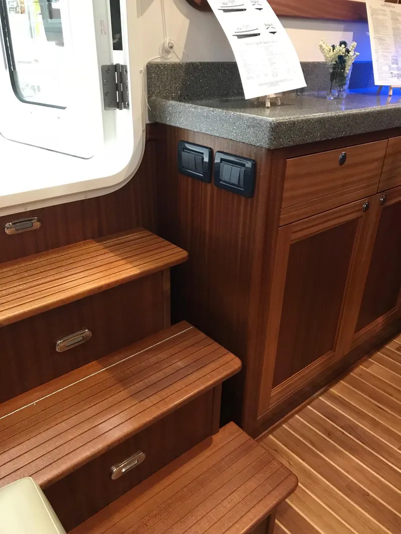Slide: The Image of Interior of 2025 Nordic Tug 34, featuring wooden steps and cabinetry. - 5