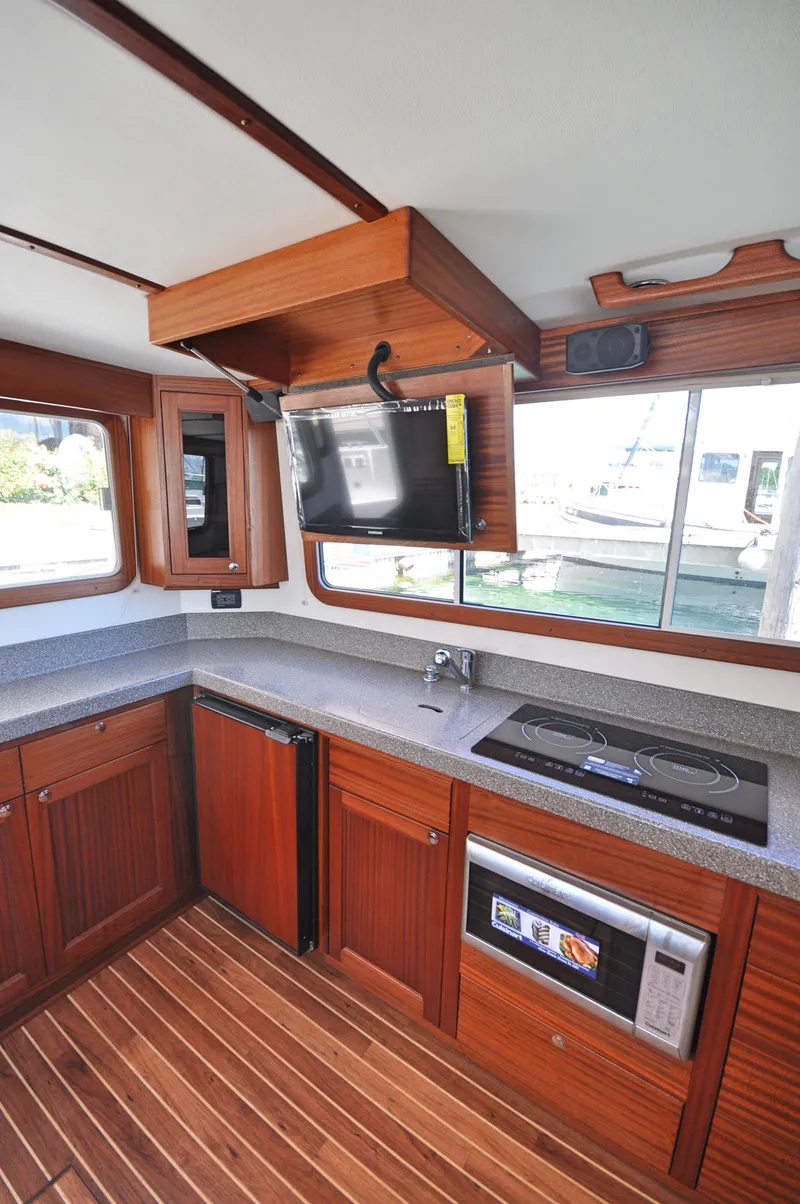 Slide: The Image of 2025 Nordic Tug 34 kitchen with modern appliances and wooden cabinetry. - 6