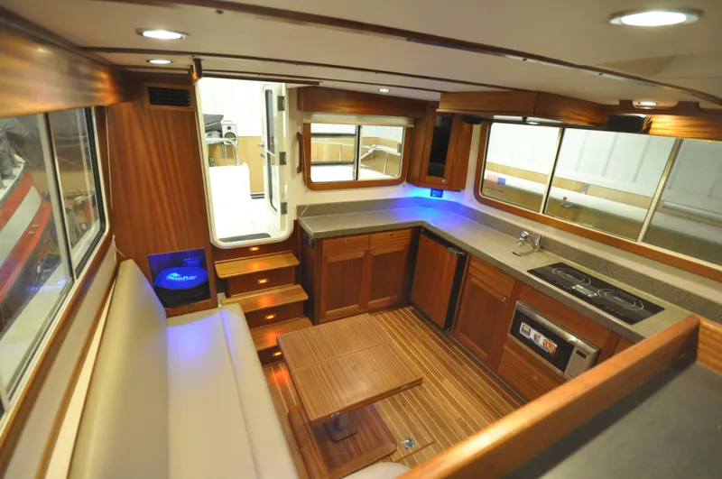 Slide: The Image of 2025 Nordic Tug 34 interior with modern kitchen and dining area. - 7