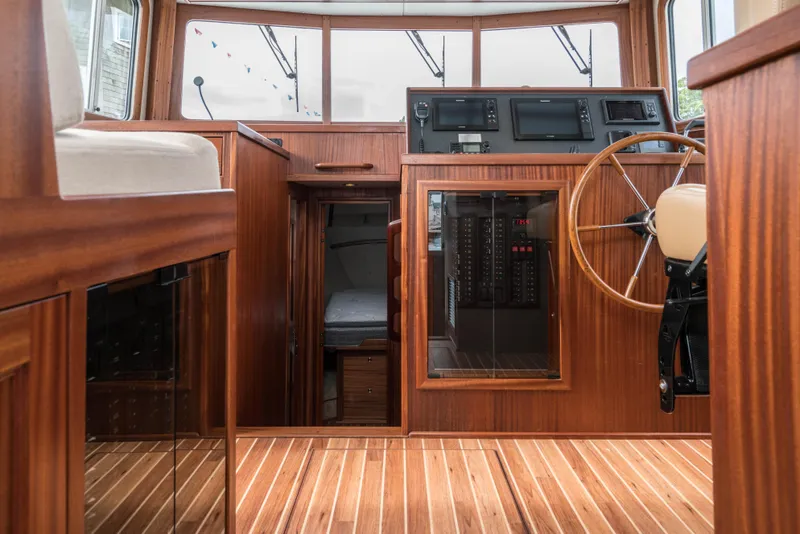 Slide: The Image of Interior of 2025 Nordic Tug 40, featuring wooden helm station and modern navigation equipment. - 10