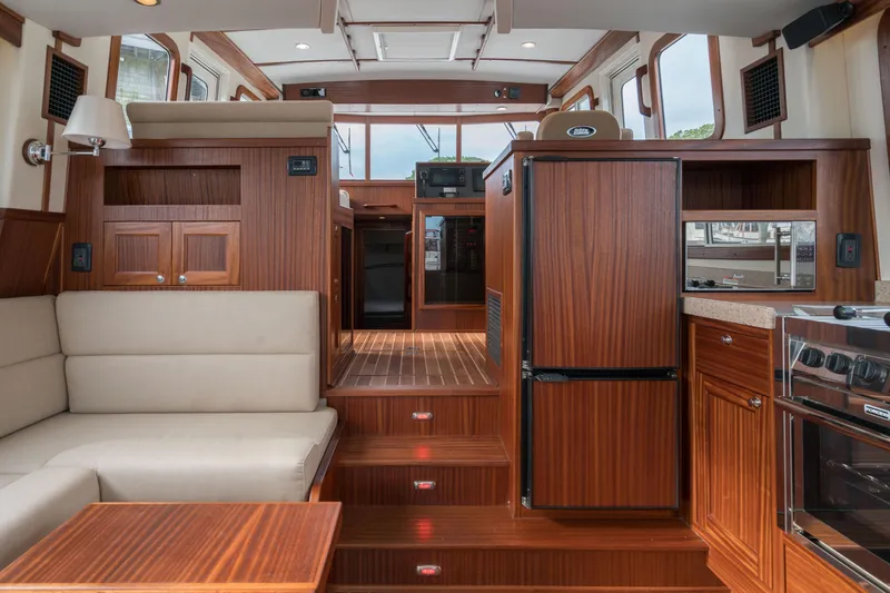 Slide: The Image of Interior of 2025 Nordic Tug 40 with wooden cabinetry and beige seating. - 8