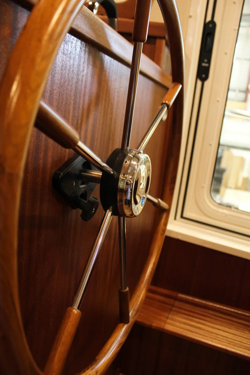 Slide: The Image of Close-up of 2025 Nordic Tug 40 wooden steering wheel and window. - 2