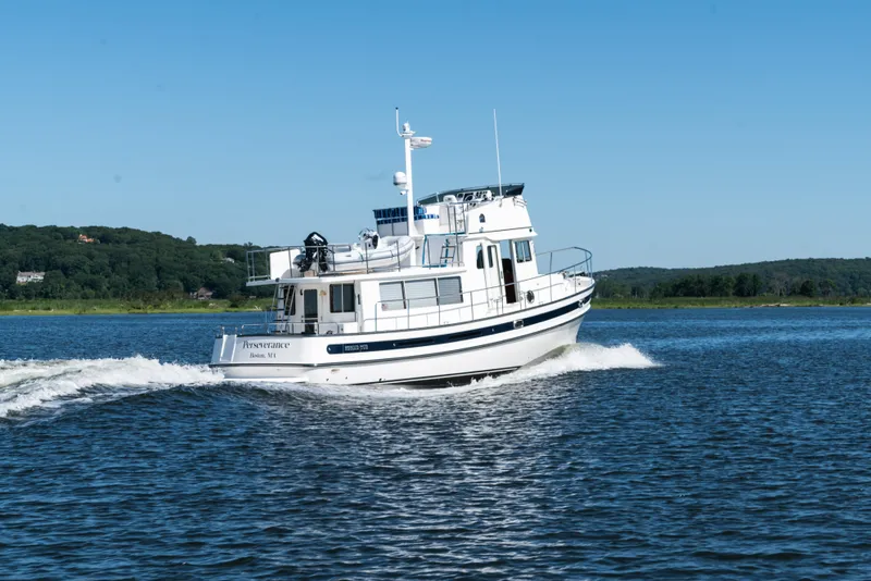 Slide: The Image of 2025 Nordic Tug 44 cruising on a scenic lake. - 10