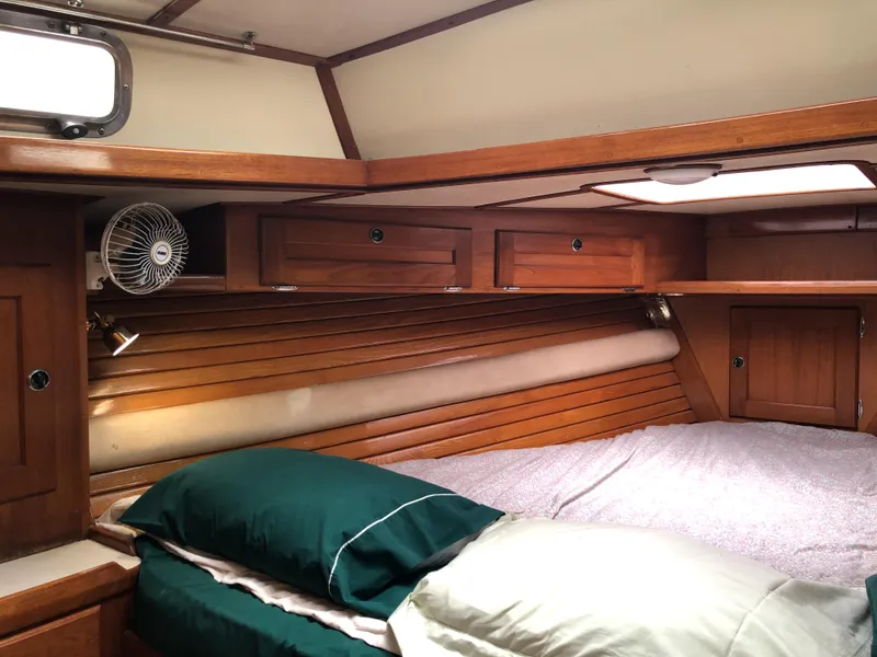 Slide: The Image of Cozy cabin interior of a 1995 Valiant 50 yacht with wooden finish and bedding. - 11