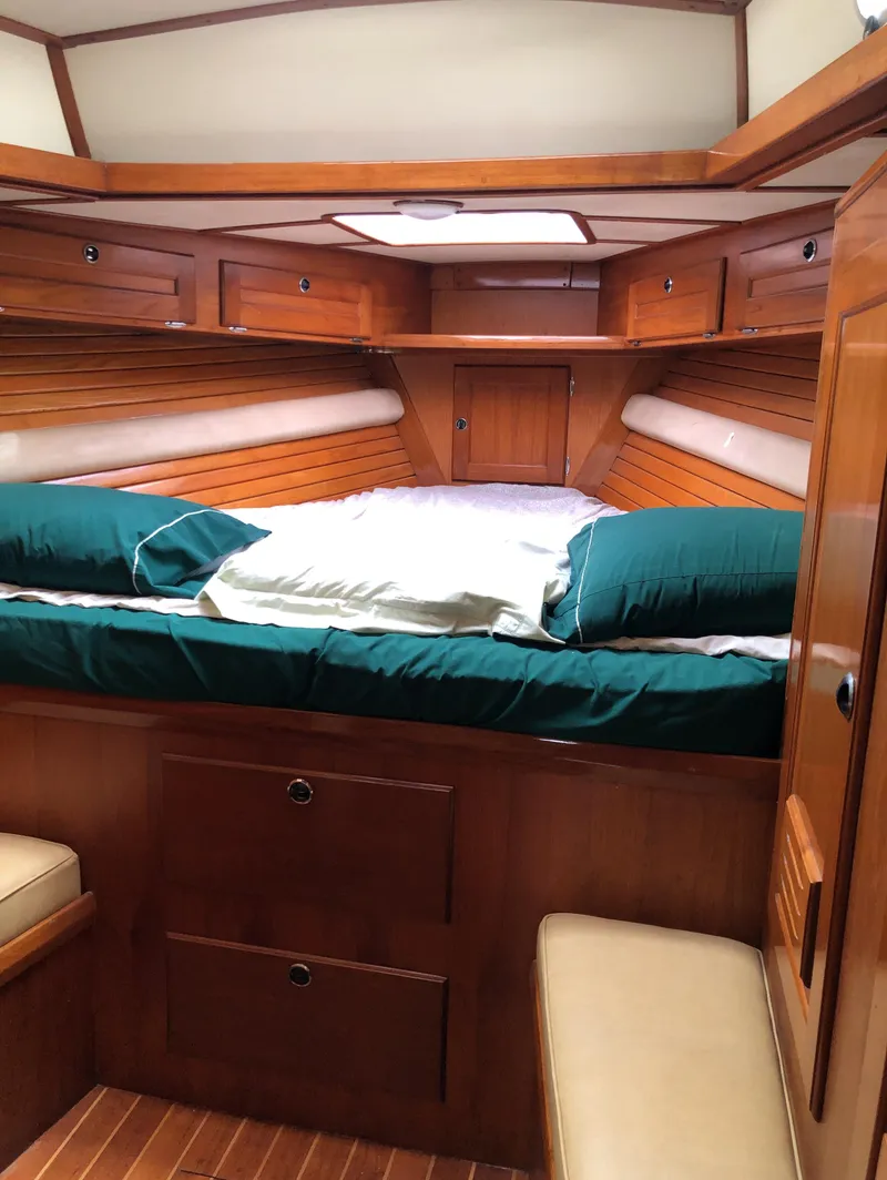 Slide: The Image of Cozy cabin interior of 1995 Valiant 50 yacht with wooden finish and green bedding. - 12