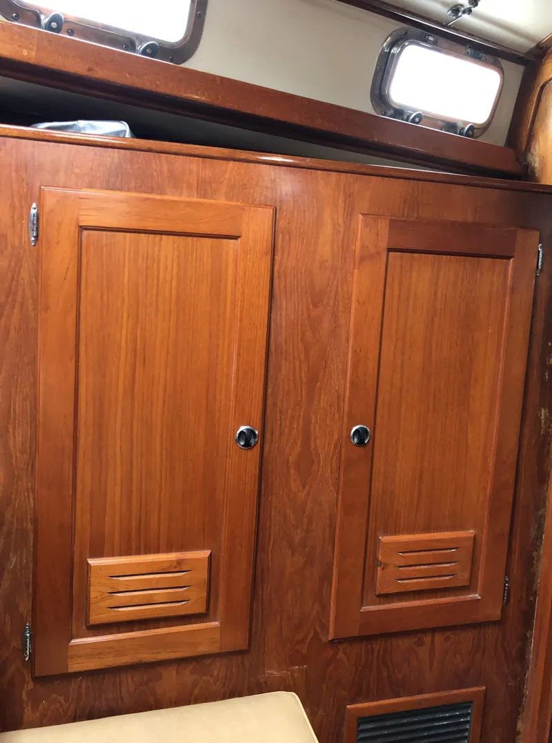 Slide: The Image of Wooden cabin interior of a 1995 Valiant 50 boat with storage compartments. - 13