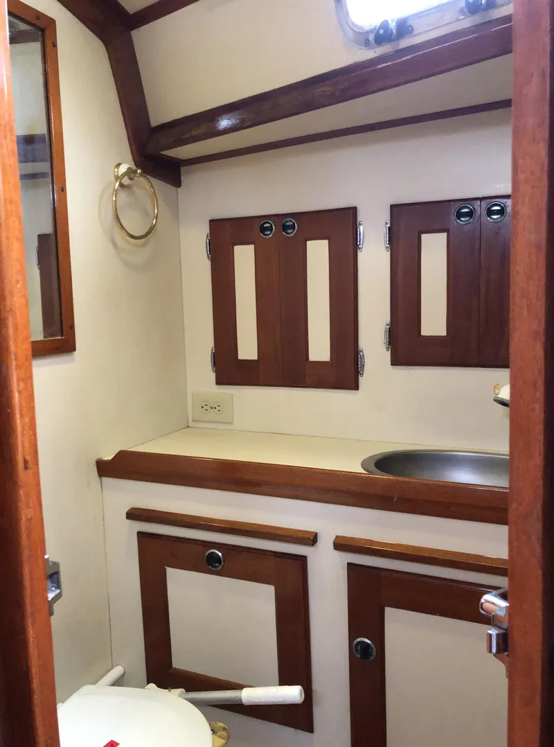 Slide: The Image of 1995 Valiant 50 yacht bathroom with wooden cabinets and stainless steel sink. - 14