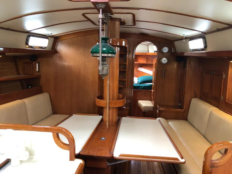 Slide: The Image of Interior of a 1995 Valiant 50 sailboat with wooden furnishings and cozy seating. - 16