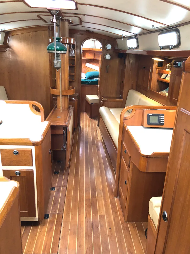 Slide: The Image of Interior of 1995 Valiant 50 sailboat with wooden furnishings and cozy seating. - 18