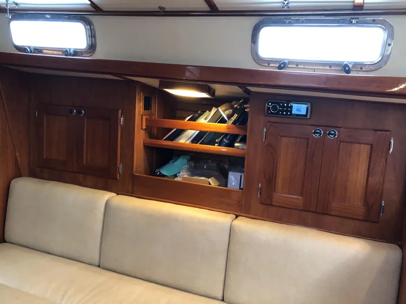 Slide: The Image of 1995 Valiant 50 yacht interior with wooden cabinets and beige seating. - 19