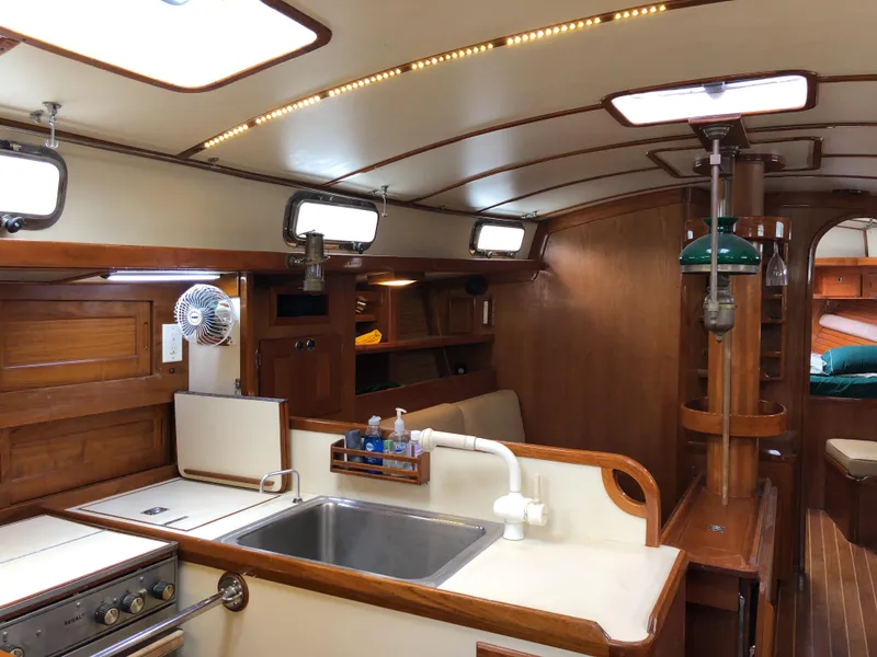Slide: The Image of Valiant 50 yacht interior, 1995 model, featuring a wooden kitchen and cozy living space. - 24