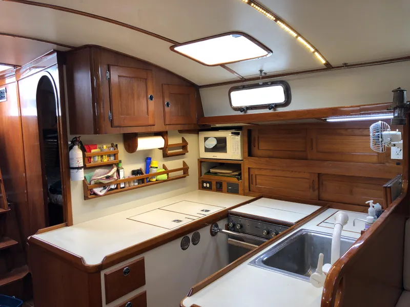 Slide: The Image of 1995 Valiant 50 yacht kitchen with wooden cabinets, stove, and sink. - 25