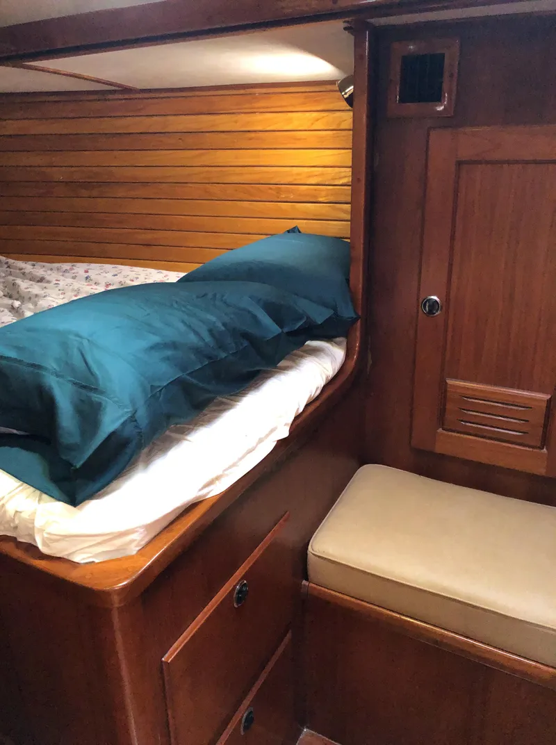 Slide: The Image of Cozy cabin interior of 1995 Valiant 50 sailboat with wooden paneling and bedding. - 31