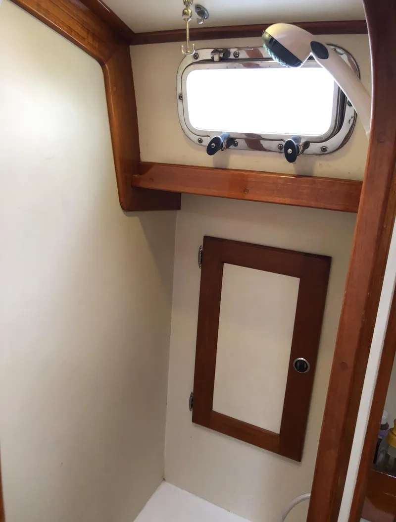 Slide: The Image of Interior of a 1995 Valiant 50 boat with wooden trim and a porthole window. - 34