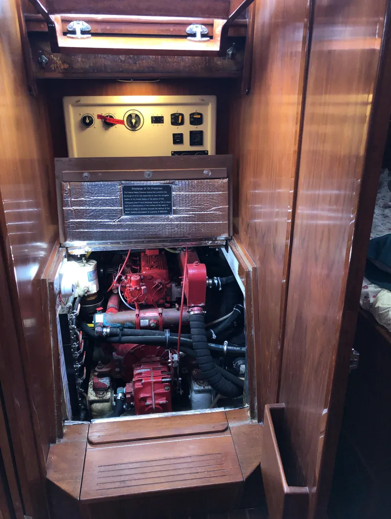 Slide: The Image of Engine compartment of a 1995 Valiant 50 sailboat, featuring control panel and red engine. - 38
