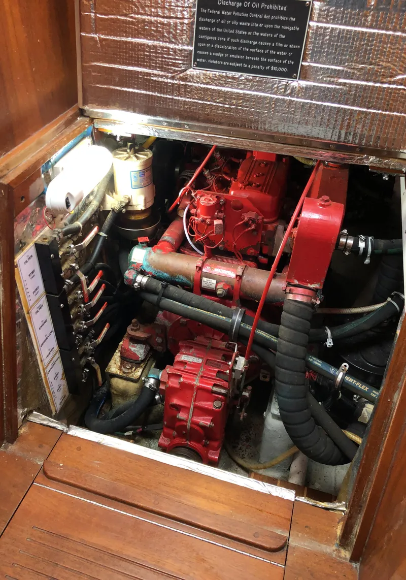 Slide: The Image of Engine compartment of a 1995 Valiant 50 boat, featuring red machinery and hoses. - 40