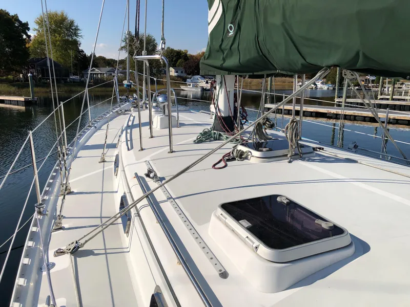 Slide: The Image of Sailboat deck of 1995 Valiant 50, docked in a serene marina setting. - 5