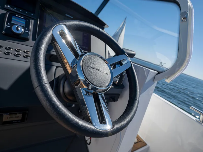 Slide: The Image of 2025 Nimbus T8 boat steering wheel and dashboard on a sunny day. - 4