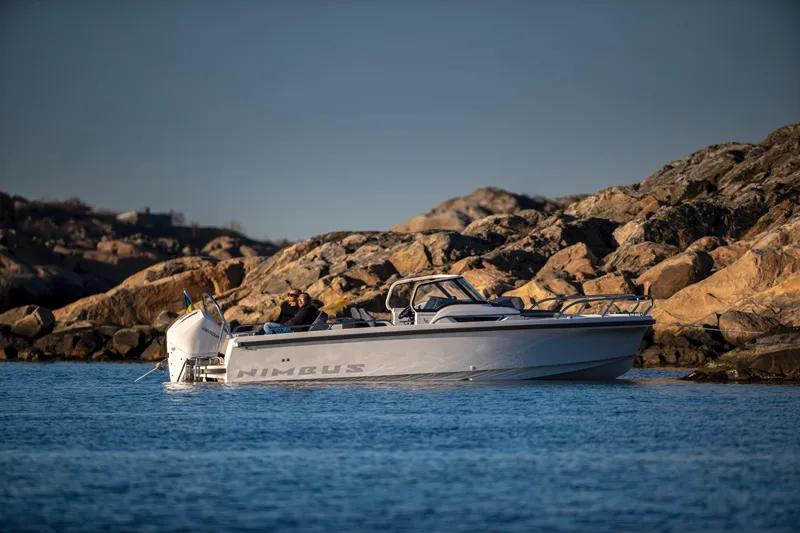 Slide: The Image of Nimbus T8 2025 motorboat cruising near rocky shoreline. - 6