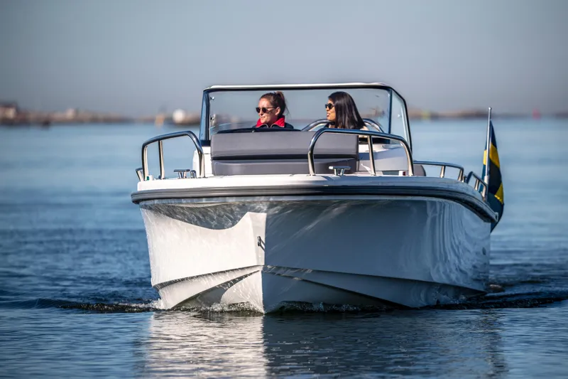 Slide: The Image of 2025 Nimbus T8 boat cruising on calm water with two passengers. - 1