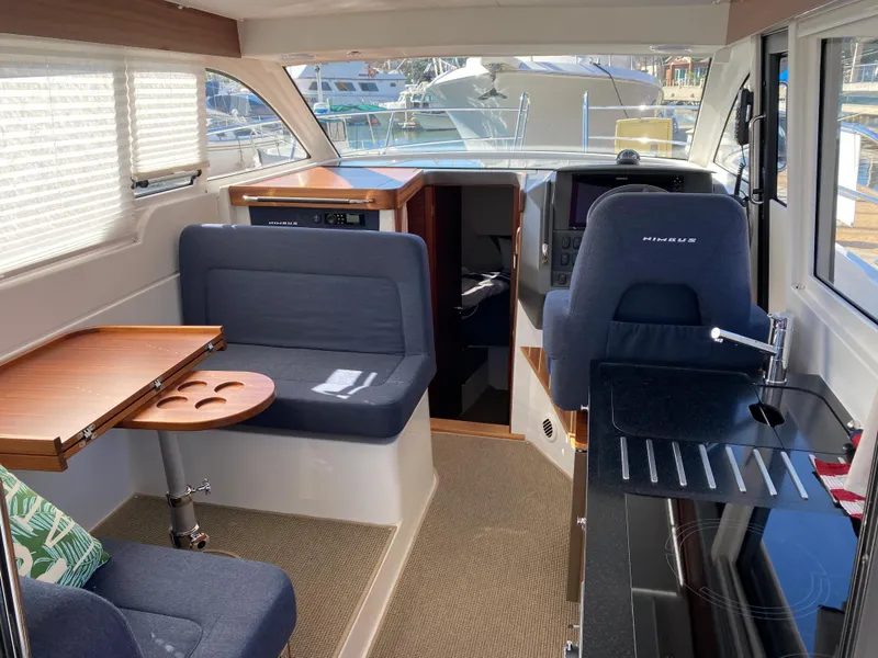 Slide: The Image of Interior of 2025 Nimbus 305 Coupe boat with seating and navigation area. - 6