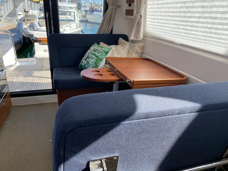 Slide: The Image of Interior of Nimbus 305 Coupe 2025 with blue seating and wooden table. - 8