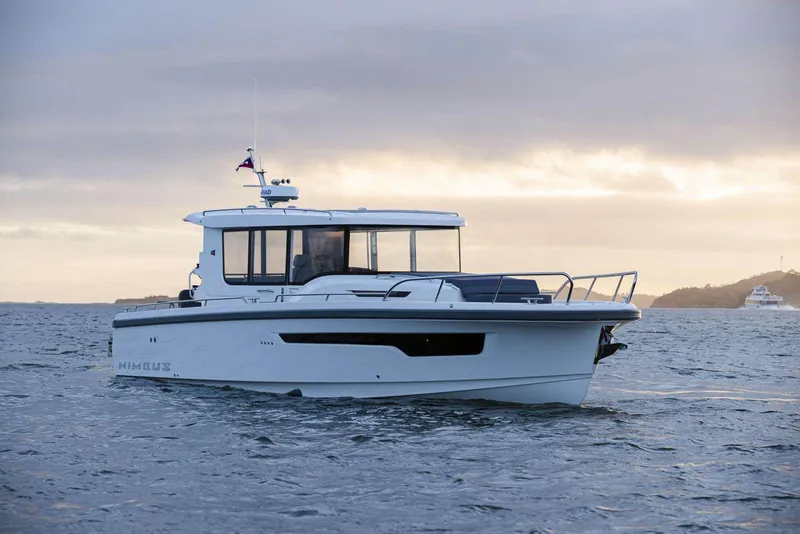 Slide: The Image of 2025 Nimbus C11 boat cruising on calm waters at sunset. - 0