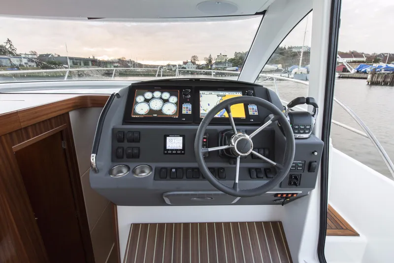 Slide: The Image of Nimbus 405 Flybridge 2025 helm station with modern navigation instruments and steering wheel. - 8