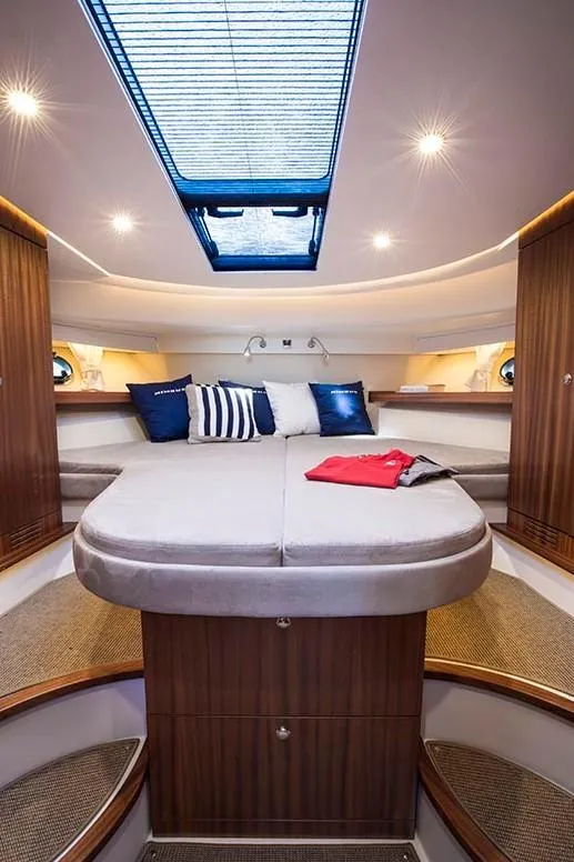 Slide: The Image of Luxurious interior of 2025 Nimbus 405 Flybridge yacht with skylight and cozy bedding. - 9