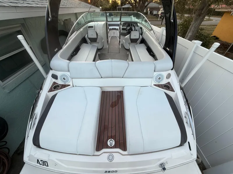 Slide: The Image of 2013 Regal 2500 Bowrider boat with white seating and wood accents, parked outdoors. - 17