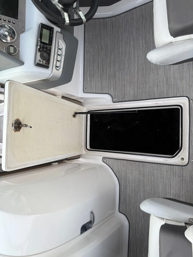 Slide: The Image of 2013 Regal 2500 Bowrider interior with open storage compartment and control panel. - 46